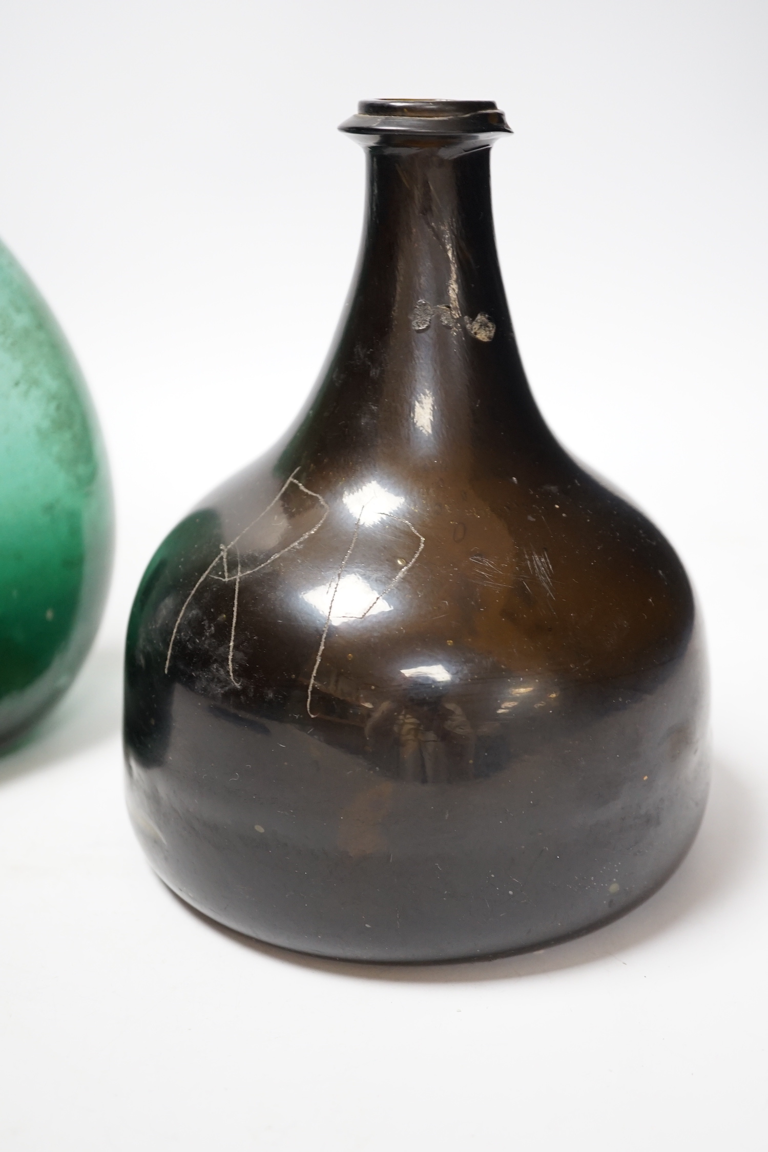 An 18th century black glass mallet form bottle with neck rim, 17cm and an 18th century Persian green glass flask, 27cm